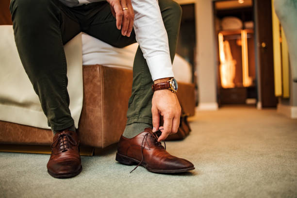 istock Businessman untying shoelaces on his shoes, low angle image, close-up. 1255362642
