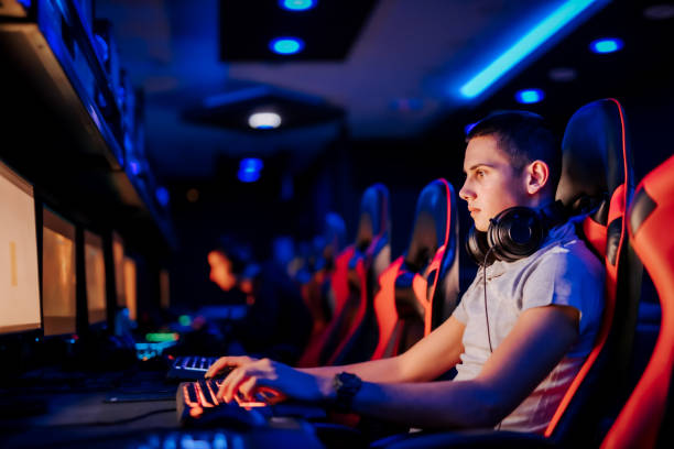 istock Close-up portrait of a focused gamer using computer at modern internet cafe. 1255362699