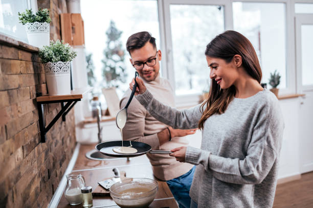 istock Millennial couple in modern rustic kitchen. Young woman making pa 1255362706