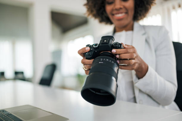 istock Journalist is holding a digital camera and looking at it, close-up, focus on the foreground. 1255363282