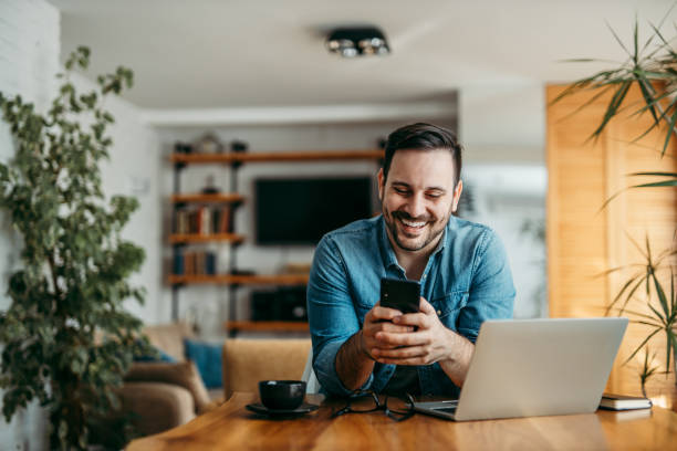 istock Portrait of a handsome man text messaging over smart phone, at home. 1255363295