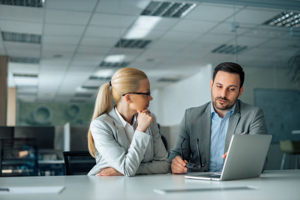 istock Two business people discussing work, portrait. 1255363296