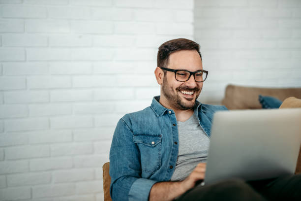 Portrait of a smiling handsome man using laptop, copy space.