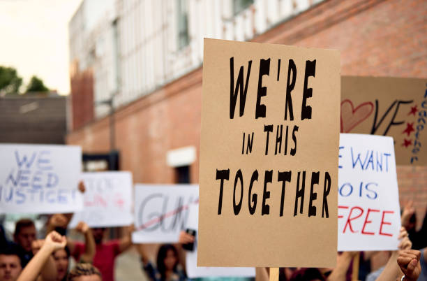 protests movement! Unrecognizable person holding a placard with We are in this together inscription during public demonstrations. social justice concept photos stock pictures, royalty-free photos & images