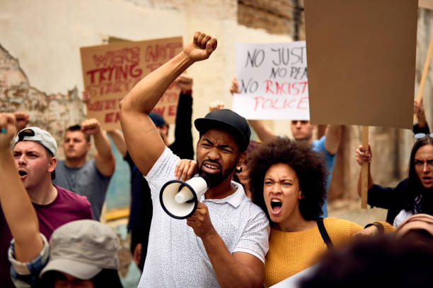 istock African American couple among crowd on people on protests protest. 1255363695