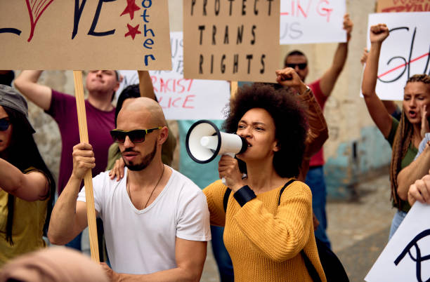 istock Large group of people protesting for human rights on city streets. 1255363716