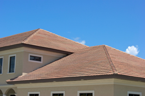 Half round clay tile roof tops on generic modern building in southwest florida