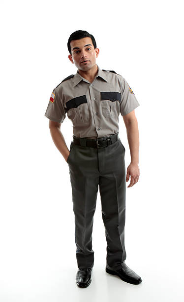 Male worker in uniform A male worker wearing uniform is standing with one hand in pocket on a white background prison guard stock pictures, royalty-free photos & images