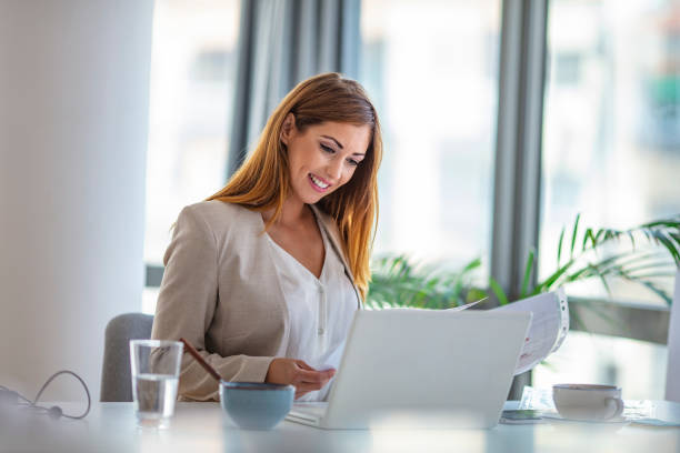 istock Successful young woman in modern office working on laptop. 1255368267