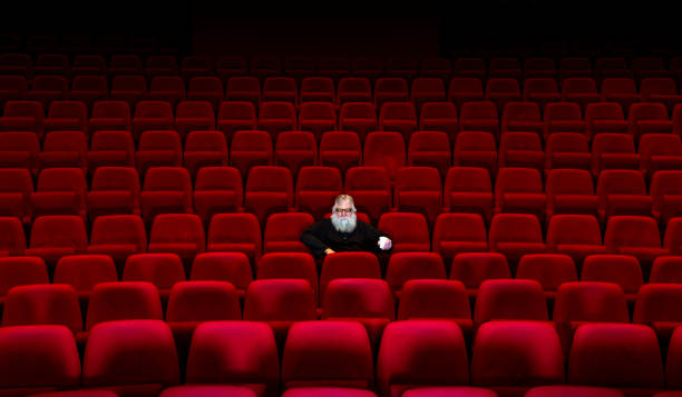 istock One man with white beard sits in Empty cinema or theatre 1255368735