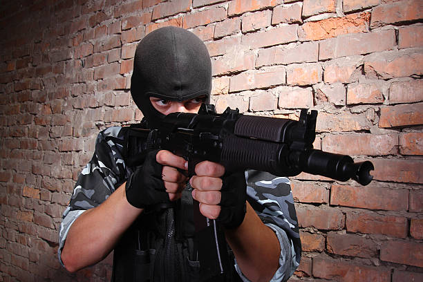 istock Armed soldier in black mask targeting with a gun 125536895