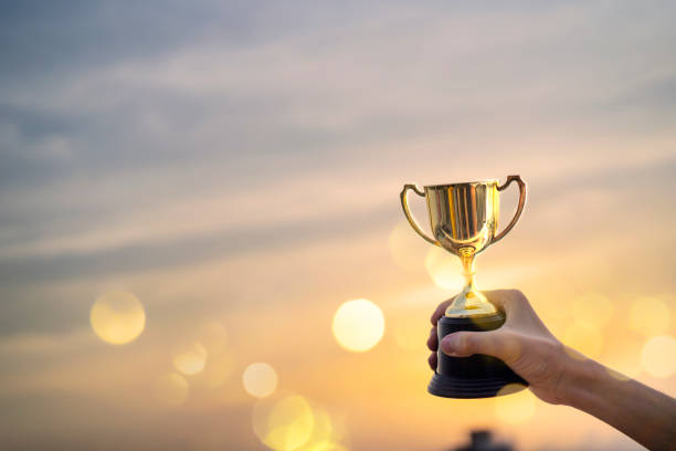 istock Business man hold a trophy showing success 1255370420