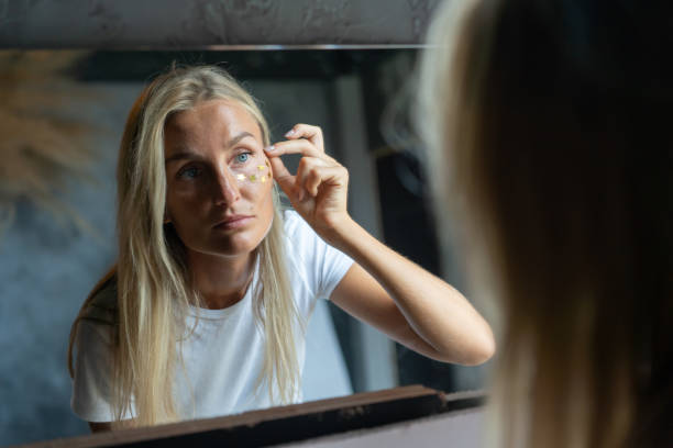 istock woman glues sparkles on her face 1255370672