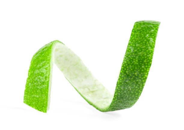 istock Green lemon twist isolated on a white background. Fresh lime peel. 1255372588