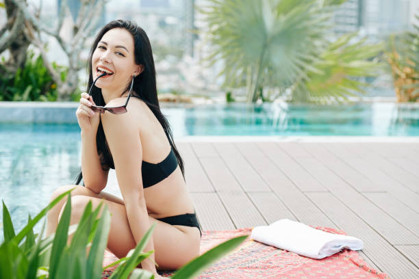 istock Attractive young woman at swimming pool 1255373422