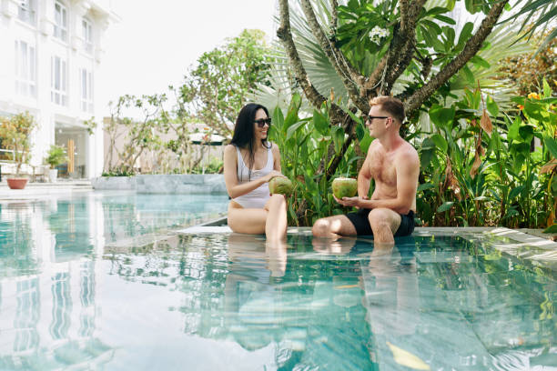 istock Man and woman resting by swimming pool 1255373453