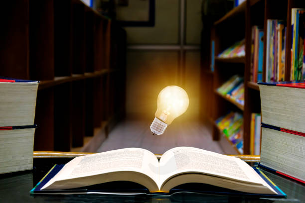 istock light bulb floating in the middle of the book 1255374665