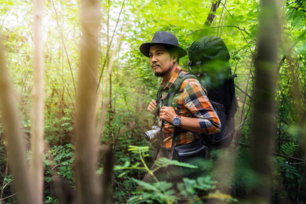 istock man traveler with backpack looking to the side walking in the forest 1255374737