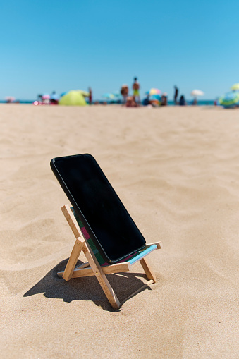 teléfono inteligente en una tumbona en la playa photo