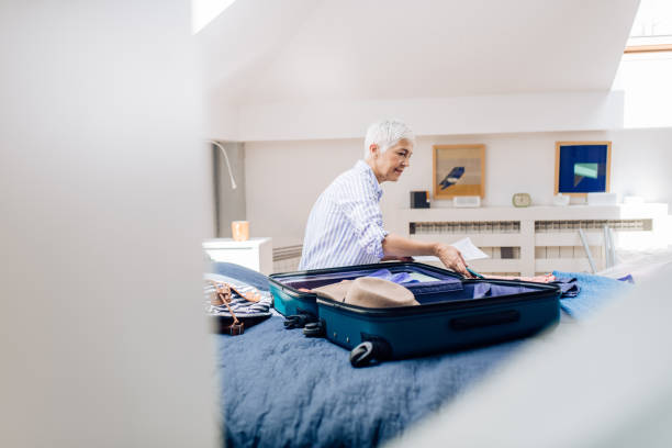 istock Senior woman packing a suitcase for a holiday 1255376323