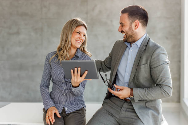 istock Happy business couple talking while working on touchpad in the office. 1255376870