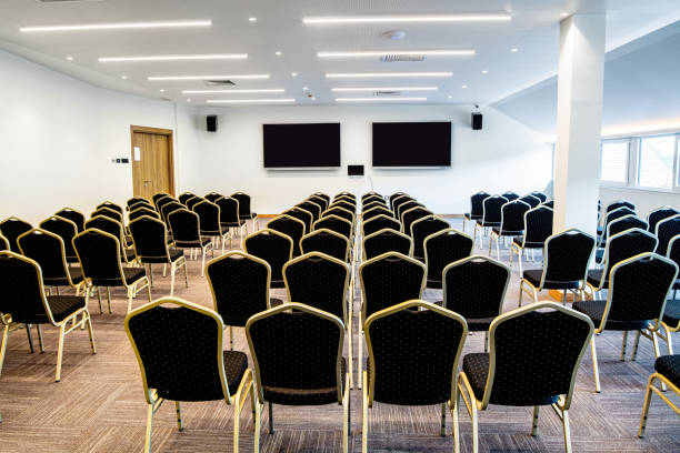 istock Conference hall with empty chairs and projection screens for video presentations. 1255381293