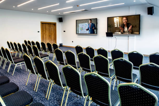 istock Two entrepreneurs holding presentation via video conference call in empty convention center. 1255382213