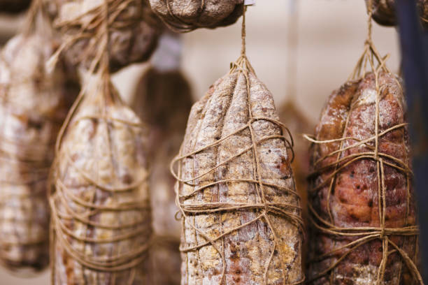 salami culatello italien accroché dans une usine selon l’ancienne tradition italienne. - salumeria photos et images de collection