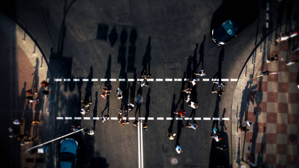 beaucoup de gens traversant un passage pour piétons sur une rue de kiev - shadow focus on shadow women sunset photos et images de collection