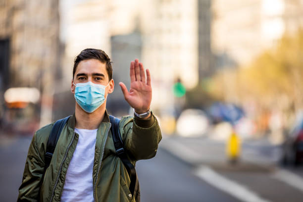 istock Stop the infection! Man with a mask gesturing stop 1255386945