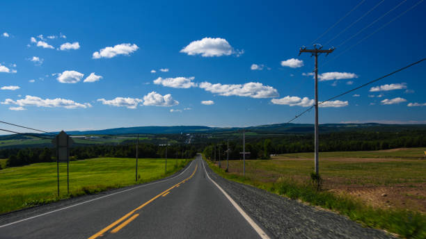 istock rural road under the summer sun in Quebec, Canada 1255386961