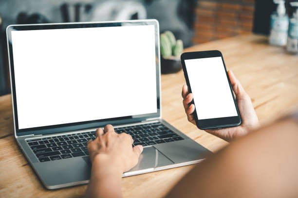 istock mockup image of a woman's hand working on a laptop and smart phone with blank white desktop copy space screen on a desk 1255387681