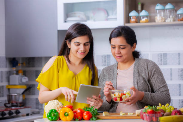 zwei junge frau in der küche - stockfoto - fruit salad fruit healthy eating making stock-fotos und bilder