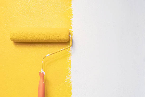istock The painter is painting the yellow wall room. 1255388806