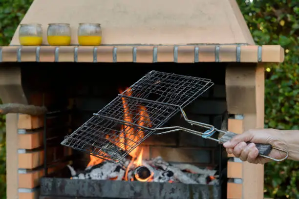 Photo of Barbecue lit and with flames, prepared to grill food on the outside. Eat in the garden.