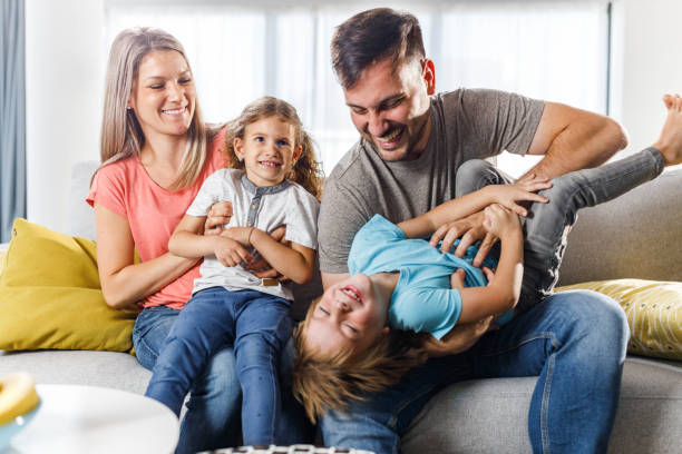 istock Cheerful parents having fun with their kids at home. 1255389619