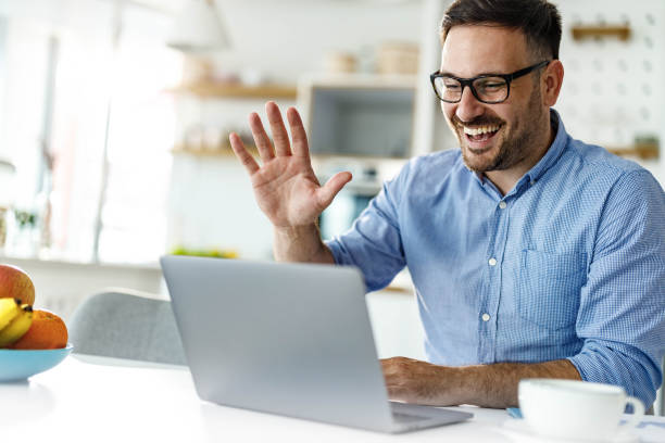 istock Happy man waving while having a video call at home office. 1255390233