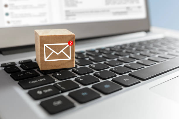 New email symbol on wooden block on laptop keyboard Email symbol on wooden block showing new message on laptop keyboard junk mail photos stock pictures, royalty-free photos & images