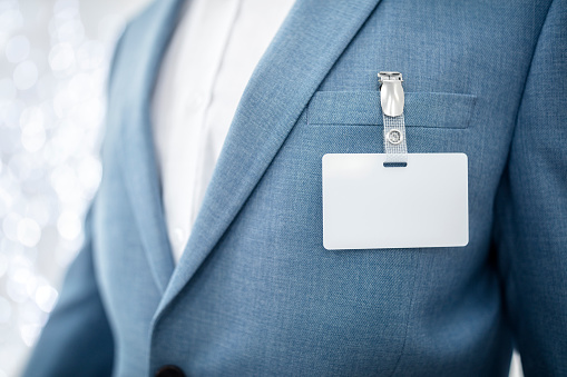 Etiqueta de nombre de seguridad en blanco en el bolsillo del traje de hombre de negocios photo