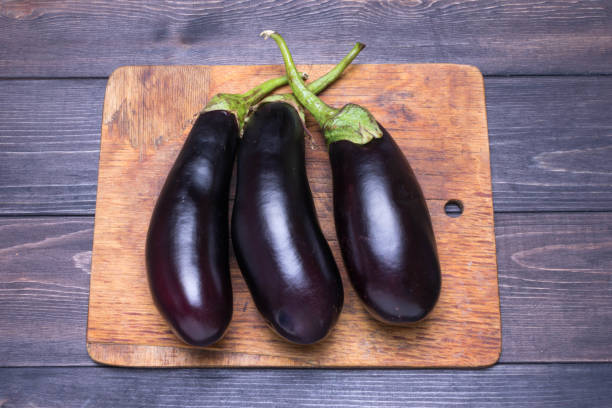 istock Purple Eggplant on blue plate on wooden background Top view Rustic style 1255393858