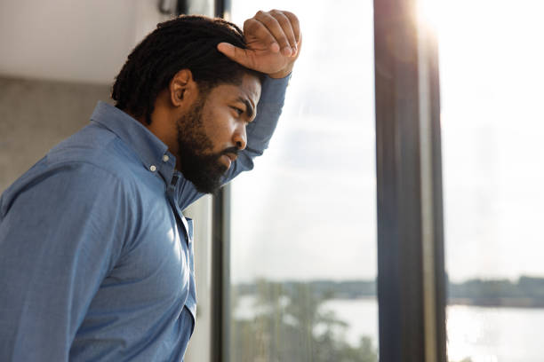 istock Worried African American businessman looking through window. 1255394331