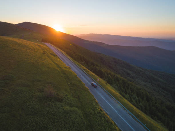 istock drone chasing car in beautiful mountains at sunset. 1255396606