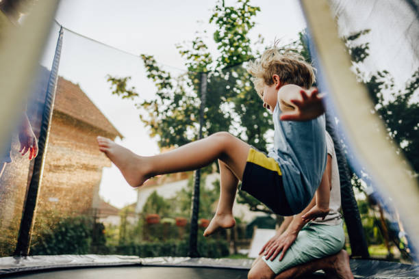 Fun on the trampoline Photo of little boy and his father having fun on the trampoline trampoline stock pictures, royalty-free photos & images