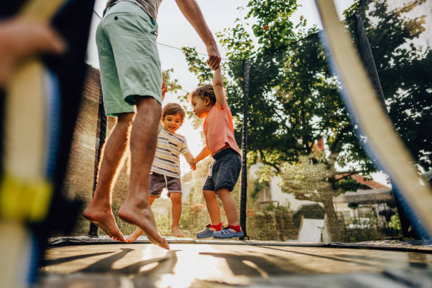 Fun on the trampoline Photo of father and his boys having fun on the trampoline trampoline stock pictures, royalty-free photos & images