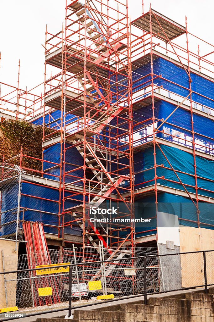 Bâtiment place avec échafaudage et drap housse de protection en plastique bleu - Photo de Clôture libre de droits