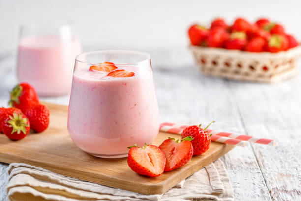 Glass with strawberry smoothie or milkshake. Glass with strawberry smoothie or milkshake on wooden table. Summer drink. smoothie photos stock pictures, royalty-free photos & images