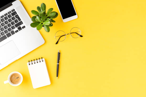 istock Office desktop. Elegant laptop with business accessories on yellow background 1255401652