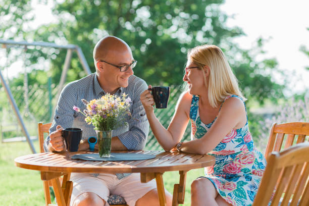 Young couple drinking coffee in the backyard in the morning