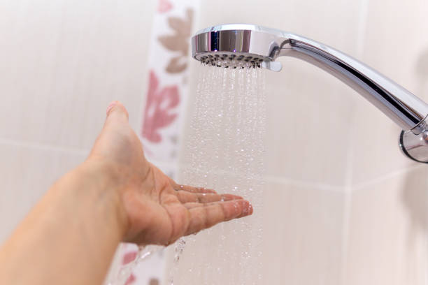 istock washing concept. Hygiene Man is checking a water temperature. 1255403419