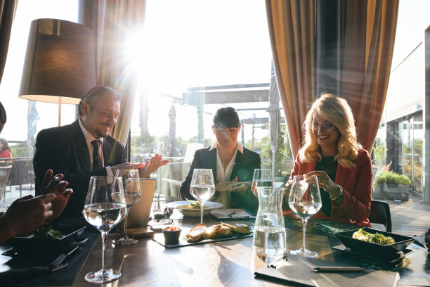 istock Group of business people using hand sanitizer before lunch 1255405122